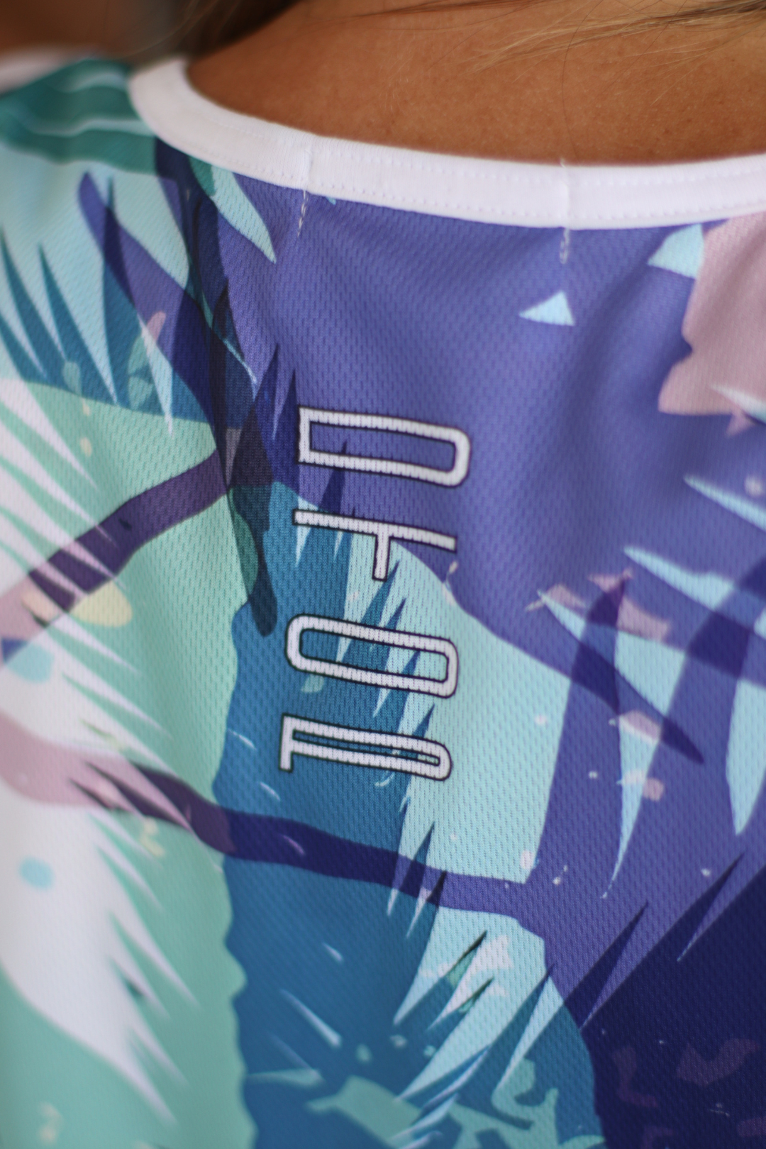 Close-up of a colorful shirt with palm leaf pattern and 'DC' logo.